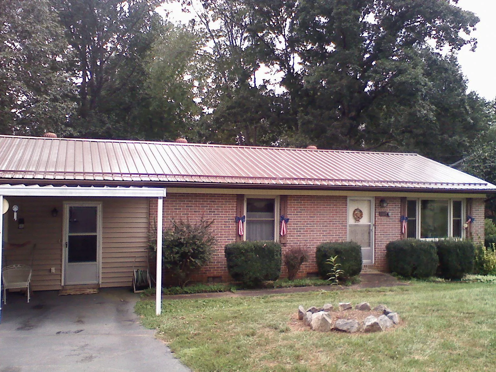 Bronze metal roof and carport on a brick ranch home — Roof Repair work by our crew in Geneva